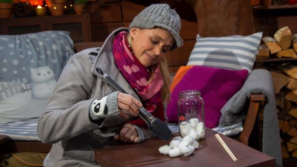 Singa hat sich ein Spiel ausgedacht: der schnelle Schneemann. Es geht darum, mit Grillzangen Wattebällchen zu transportieren.