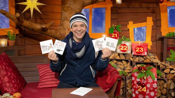 Juri hat vier Karten mit gemalten Weihnachtsmotiven in der Hand.