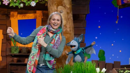 Singa und Fidi lachen im Baumhaus und bewegen ihre Arme.