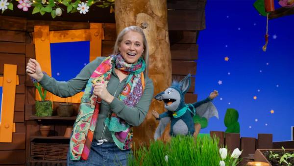 Singa und Fidi lachen im Baumhaus und bewegen ihre Arme.