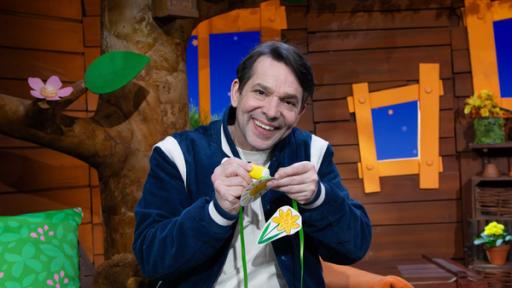 Juri bastelt die MACH MiT!-Frühlingsgirlande. Er klebt eine gelbe Sonne an den Faden.