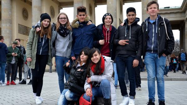 Die acht Jugendlichen haben sich gerade erst kennengelernt und wollen nun Berlin erobern. Sie fangen erstmal beim Brandenburger Tor an.  Spaß haben sie jetzt schon:  Malina, Millane, Akram, Linus, Seyid, Oscar (von links nach rechts, stehend),  Bayan und Rashad (vorne).