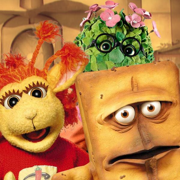 Bernd das Brot sitzt vor einer weißen Raufasertapete.