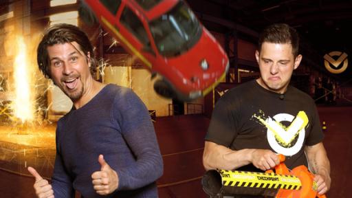 Crashtests - Widerstand ist zwecklos! | Rechte: ZDF Checkpoint: Der Moderator der Sendung, Tommy Scheel, streckt die Zunge heraus und streckt beide Daumen nach oben. Ein grimmig schauender Junge rechts neben ihm hält eine Art Laubbläser und im Hintergrund stürzt ein Auto von der Decke.