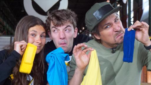 Heiße Windeln, Faustschläge und ohne Sicht | Rechte: ZDF Checkpoint: Maja, Felix und Tommy Scheel halten gemeinsam Sportlerwäsche hoch und an ihre Nasen, und riechen daran mit angeekeltem Gesichtsausdruck.