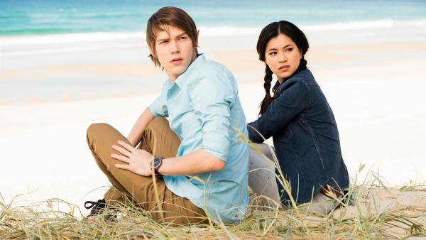 Darra (Julian Cullen links) und Kyra (Kimie Tsukakoshi rechts) haben ein magisches Portal passiert und sind an einem unbekannten Strand gelandet.  Doch nun ist das Portal verschwunden und ihnen der Rückweg versperrt.