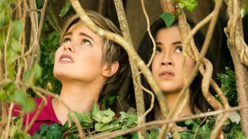 Imogen und Kyra sitzen in einem Gebüsch.