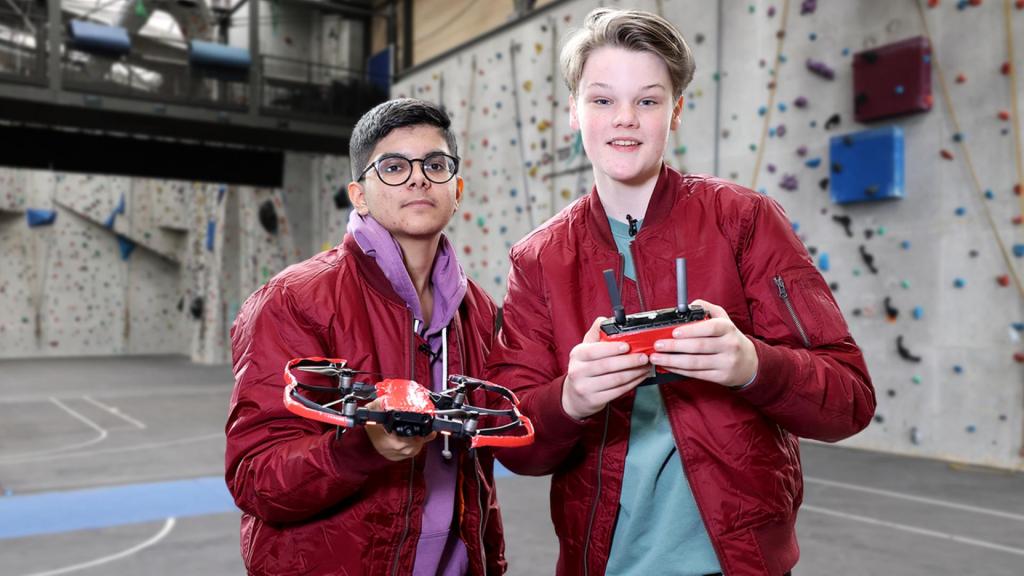 Das Zockerhaus: Ron und Dennis von Team rot halten eine Drohne und einen Controller in den Händen. 