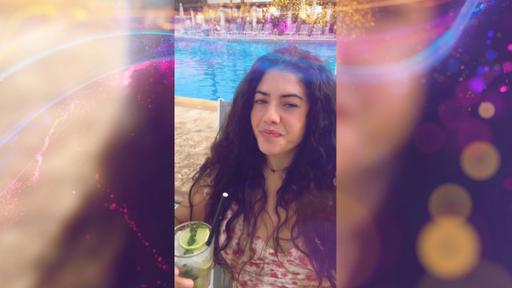 Jeannie nimmt sich in einem Hochkantvideo auf. Sie sitzt mit einem Cocktail am Pool.