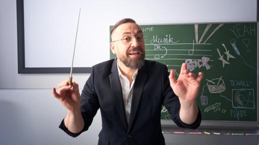Musikdoktor - Arrangement | Rechte: ZDF Bürger Lars Dietrich ist der Musikdoktor dirigiert vor einer Schultafel.