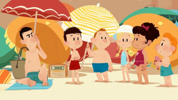 Papa, Nick und seine Freunde am Strand. Dahinter viele bunte Sonnenschirme.