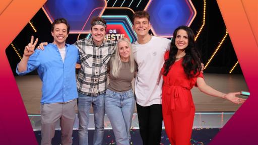 Rechte: KiKA/Steffen Becker Tobi, Fabian Baggeler, Maria Ziffy, Gregor Häfele und Clarissa stehen eng nebeneinander in einer Reihen und lächeln. Im Hintergrund das Studio mit dem Logo von Die beste Klasse Deutschlands.