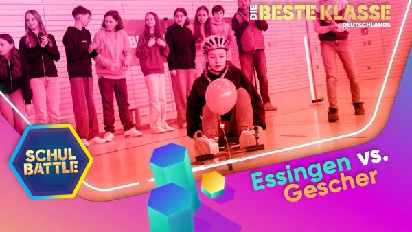 Vorne ein Mädchen mit Schutzhelm auf einem fahrbaren Untersatz mit Luftballon in einer Turnhalle. Sie schaut konzentriert. Dahinter stehen Mädchen und Jungen.