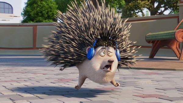 Igel Elvis mit Kopfhörern auf den Ohren. Er muss niesen, so dass all seine Stacheln weit abstehen und er leicht vom Boden abhebt.