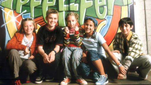 Die Pfefferkörner der ersten Generation | Rechte: NDR Fiete, Cem, Vivi, Jana und Natascha sitzen vor einer bunten Graffiti Wand.