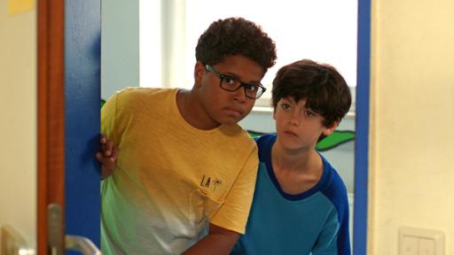 Kofi (Mathieu Noël) und Piet (Noah Lusander) lauschen an Arnes Bürotür.