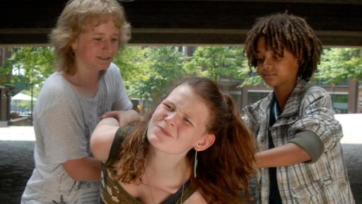 Rasmus( Julian Winterbach) und Themba (Coco Nima) halten ein Mädchen fest