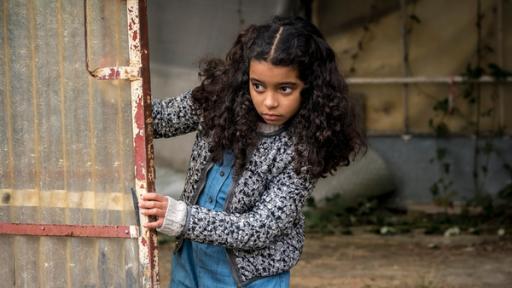 Die verschwundene Münze | Rechte: NDR/Letterbox - Boris Laewen Amy schaut in einer verlassenen Fabrik vorsichtig hinter einer Tür hervor.