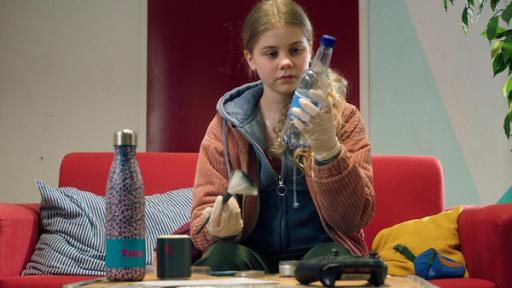 Malin sitzt auf einem Sofa und sichert Fingerabdrücke von verschiedenen Gegenständen.