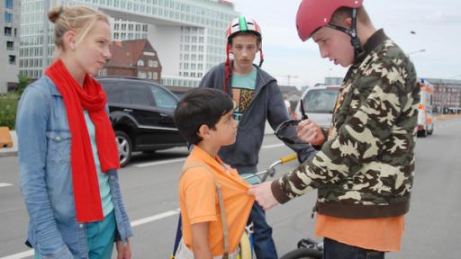 Mutproben | Rechte: NDR/Studio Hamburg - Romano Ruhnau Jessi (Martha Fries) schaut zu einem Jungen mit BMX-Helm (David Riske), der eine Sonnenbrille in der Hand hält und Luis (Emilio Sanmarino, Mitte) am T-Shirt packt. Ein weiter Junge mit Helm schaut zu (Benjamin Falk, hinten)