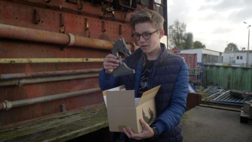 Nächstes Level | Rechte: NDR/ Screenshot Benny hält ein Karton und ein Figur in der Hand.