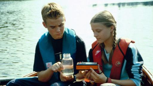 Tödlicher Müll | Rechte: NDR/Letterbox Fiete und Natascha nehmen eine Wasserprobe in der Elbe.