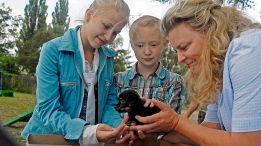 Sophie (Katherina Unger), Emma (Aurelia Stern) und die Tierärztin Frau Abraham mit einem Welpen.