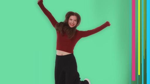 Josefine springt fröhlich in die Luft und lächelt in die Kamera. 