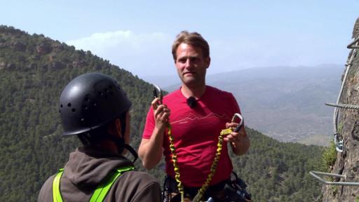 Durch die Wildnis - Sierra Nevada (S04/E12) | Rechte: E+U-TV Film- und Fernsehproduktion Coach Tobi erklärt den Gurt und die Sicherung, bevor die Sechs an den Klettersteig an der Steilwand dürfen