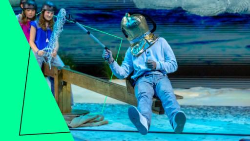 Am Meer | Rechte: ZDF / Katja Inderka "Earthgame - Die Bodenretter": Ein Mitglied der "Ocean Youngsters" sitzt mit einem geschlossenen Taucherhelm auf dem Kopf auf einer Wippe im Earthgame-Studio und fischt Müll vom Boden.