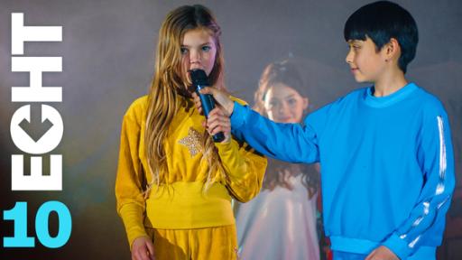 Staffel 2, Folge 10 | Rechte: ZDF Im Bühnenlicht und von leichtem Nebel umgeben, stehen Celina (Lia Kahtin, l.) und Noah (Hauke Tài Hoàng) nebeneinander. Celina spricht in ein Mikrofon das Noah ihr vor den Mund hält. Im Hintergrund sieht man ein selbst gestaltetes Plakat und Leyla (Aleyna Kuş).