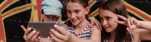 Drei Mädchen machen gemeinsam ein Handy-Selfie.