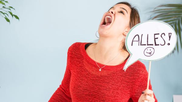 Anna hält eine Sprechblase mit dem Wort ALLES hoch.