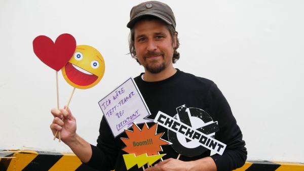 Checkpoint-Moderator Tommy Scheel mit Emojis in den Händen