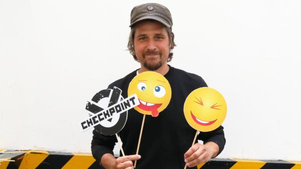 Checkpoint-Moderator Tommy Scheel mit Emojis in den Händen