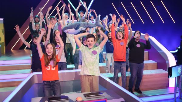 Zwei Schüler*innen-Teams sitzen an den Quiz-Pulten im DbKD-Studio. Im Hintergrund sitzen ihre Schulklassen.