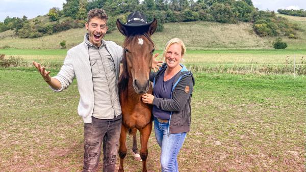 Jason mit einem Quarter Horse und Pferdezüchterin Iris. Das Pferd trägt einen Cowboyhut.