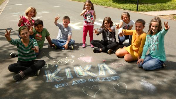 Kinder mit einem gemalten KiKA-Logo