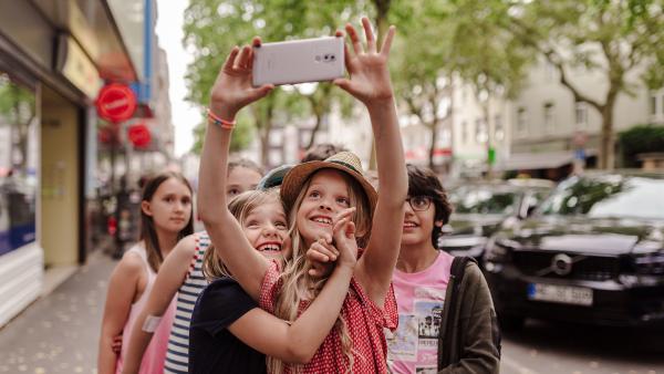 Ein Mädchen macht von sich un dihren Freund*innen ein Selfie