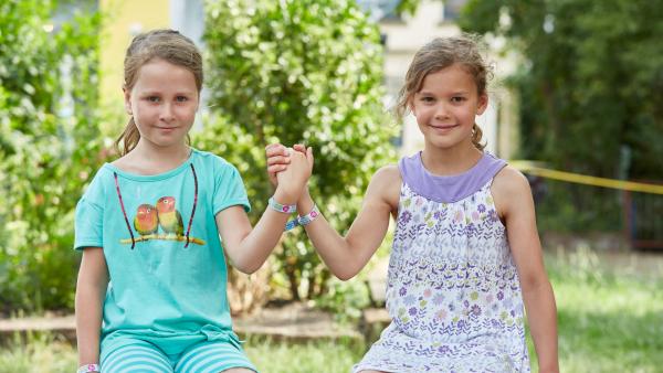 Zwei Kinder halten sich an der Hand