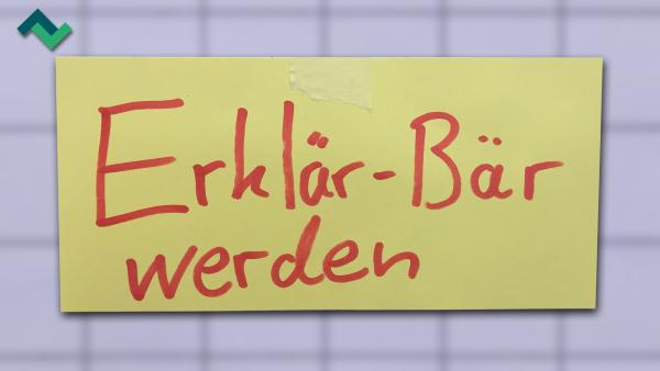 Ein gelber Notizzettel, auf dem das Wort "Erklärbär" geschrieben ist.