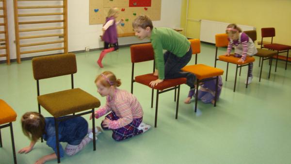 Kinder kriechen durch oder steigen auf Stühle