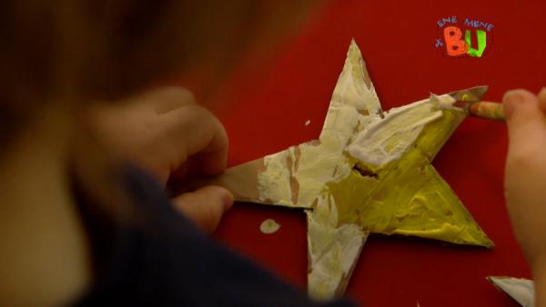Auf dem Bild seht ihr einen ausgeschnittenen Stern aus Papier. Dieser wird vom Kind bemalt. 