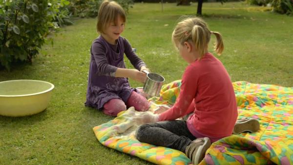 Kinder mischen Mehl und Wasser