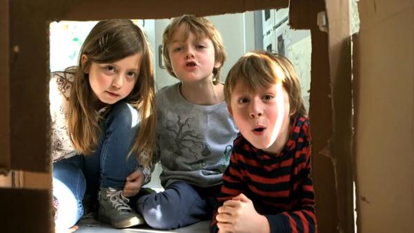 Drei Kinder in Haus aus Pappe