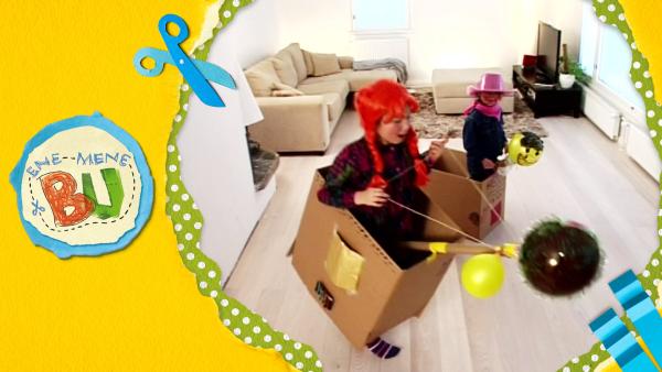 Rianna und Nanna reiten auf gebastelten Pferden aus Pappkarton, Ballon und Papierrollen.