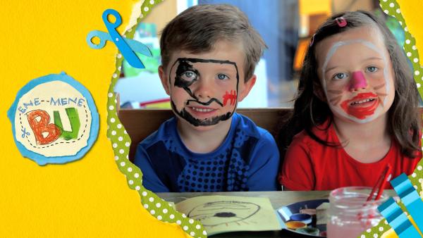 Theresa und Moritz sitzen mit Kinderschminke geschminkt vor ihrem selbstgemachten Schminkbuch