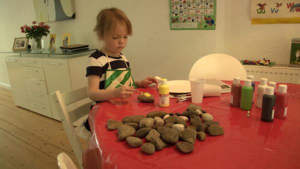 Leni malt einen Stein an.
