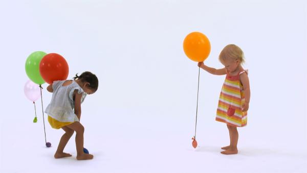 Ida und Ida verteilen Ballons.
