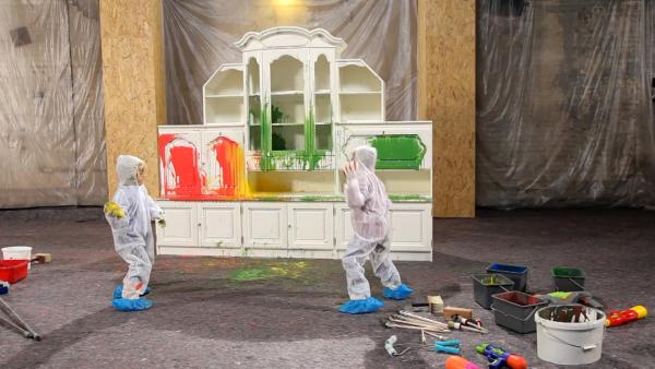 Kinder werfen Farbbomben auf einen alten Schrank.